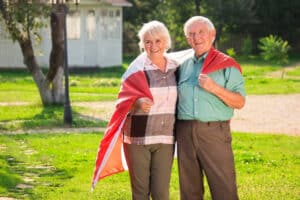 Elderly couple wrapped in flag.
